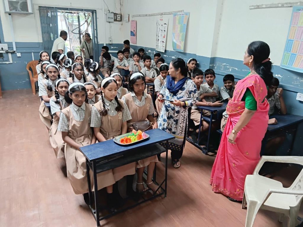 A presenter addressing seated students during a school awareness visit
